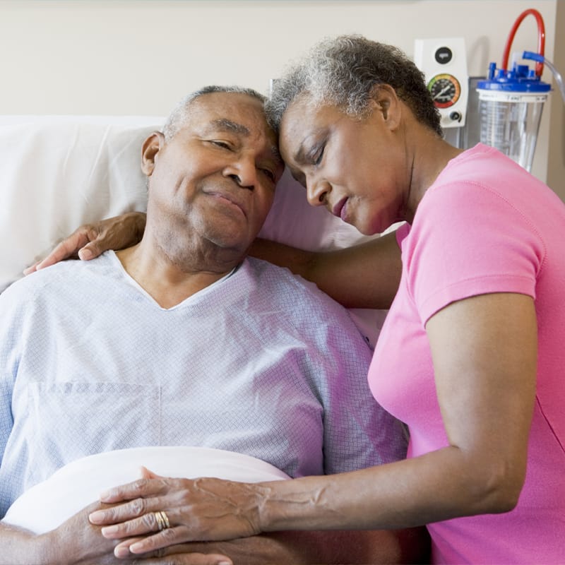 Person comforts partner in hospital gown