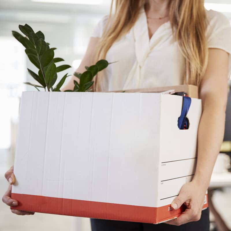 Person holds box of items from desk